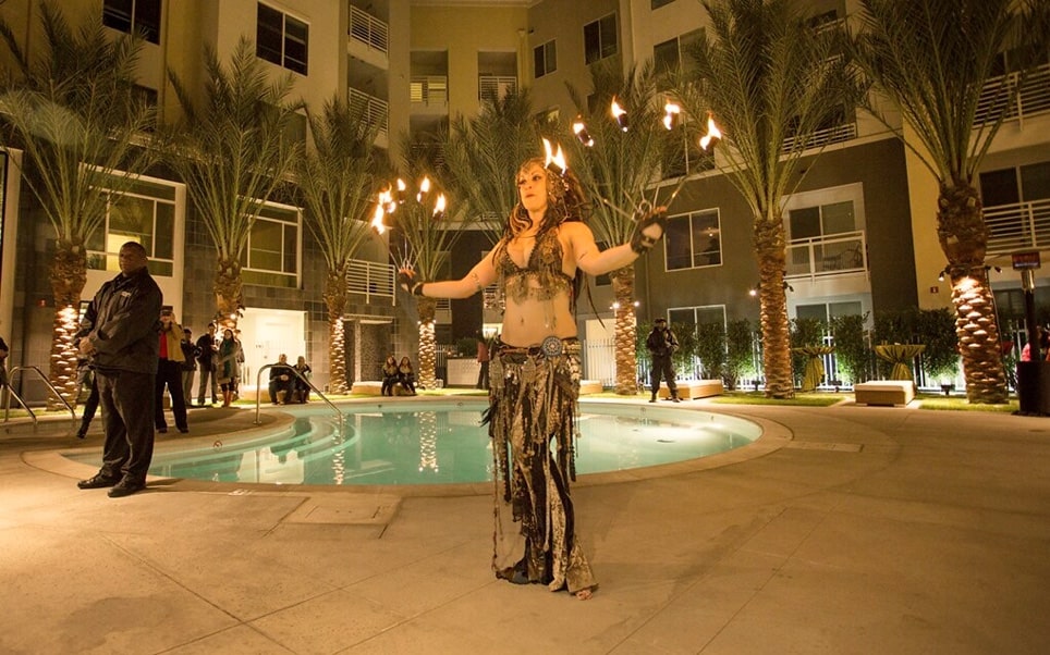 Performer with fire sticks by the apartment pool.